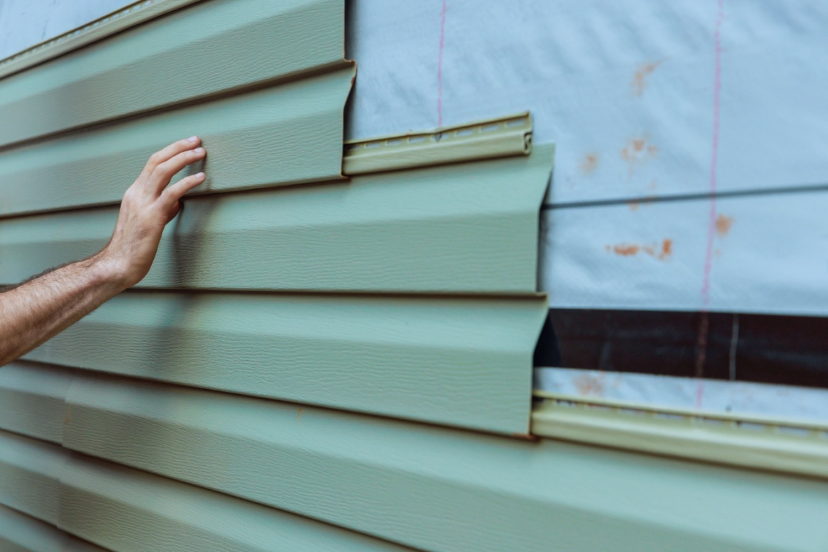 A professional installing new vinyl siding